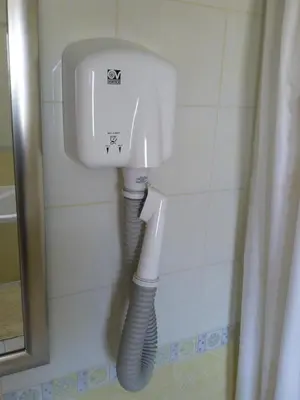 a white toilet in a bathroom with a pipe at Vila Bbq in Ljubljana