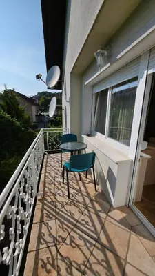 a patio with two chairs and a table on a balcony at Vila Bbq in Ljubljana
