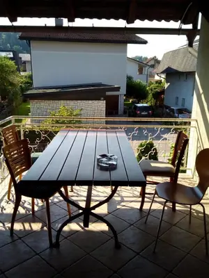 a wooden table and chairs on a patio at Vila Bbq in Ljubljana