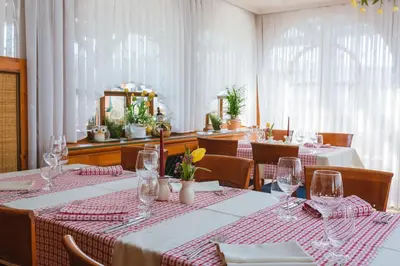 a dining room with tables with red and white tablecloths at Guesthouse Tulipan in Lesce