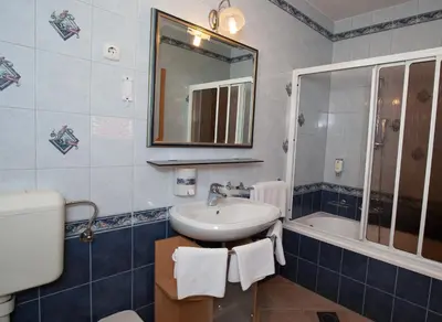 a bathroom with a sink and a mirror and a tub at Guesthouse Tulipan in Lesce