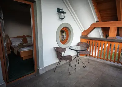a balcony with a table and chairs and a bed at Guesthouse Tulipan in Lesce