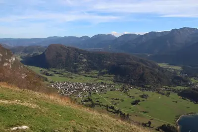 a small town in a field in the mountains at Apartments & Hostel Bohinj in Bohinj