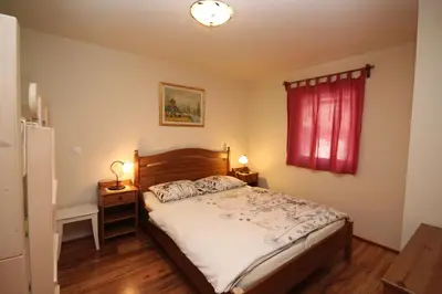 a bedroom with a bed and a red window at Apartments Na Vasi in Bohinj