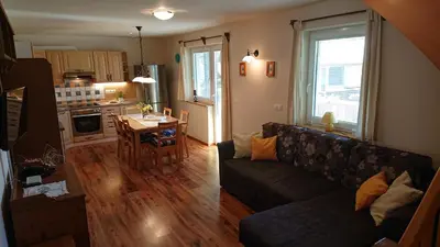 a living room with a couch and a table at Apartments Na Vasi in Bohinj