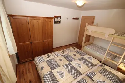 a bedroom with a bed and a bunk bed at Apartments Na Vasi in Bohinj