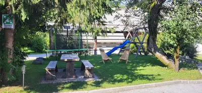 a park with a playground with a slide and benches at Apartments Na Vasi in Bohinj