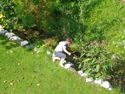 a young boy picking flowers in a garden at The Millhouse Bled in Bled