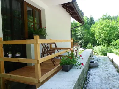 a wooden deck with a table and chairs on a house at The Millhouse Bled in Bled