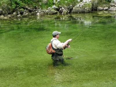 a man in the water with a backpack holding onto a string at The Millhouse Bled in Bled