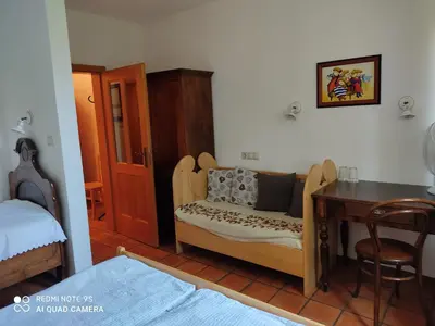 a bedroom with a desk and a table with a couch at Bed & Breakfast Na Poljani in Kranj
