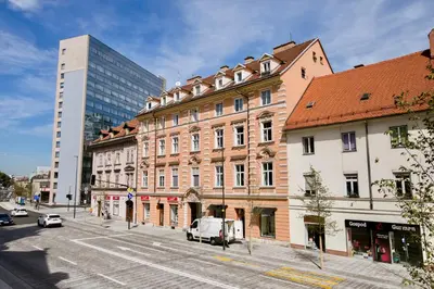 a street in a city with buildings and a van at Apartment Optim in Ljubljana