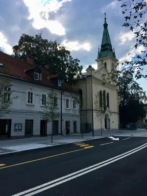 a building with a clock tower on the side of a street at Apartment Optim in Ljubljana