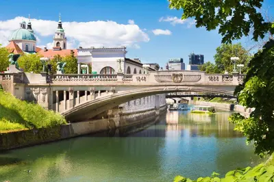 a bridge over a river in a city at Apartment Optim in Ljubljana