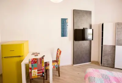 a kitchen with a table and a yellow refrigerator at Apartment Optim in Ljubljana