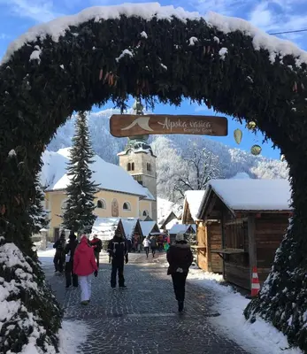 a group of people walking down a street in the snow at Apartma Stenar in Mojstrana