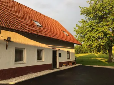 a building with an orange roof and a tree at Apartma Stenar in Mojstrana