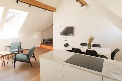 a kitchen and living room with a table and chairs at Central Riverside Apartments Meščanka in Ljubljana