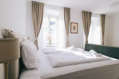 two beds in a room with a window at Central Riverside Apartments Meščanka in Ljubljana