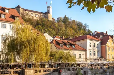 a town with a castle on top of a hill at Central Riverside Apartments Meščanka in Ljubljana