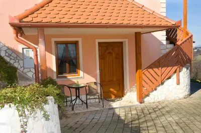 a small house with a wooden door and a table at PLANINCA -hiša z razgledom in Šmarje pri Jelšah