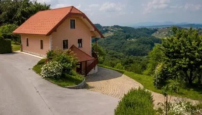 a small house with a red roof on a road at PLANINCA -hiša z razgledom in Šmarje pri Jelšah