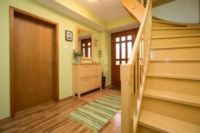 a hallway with stairs and a door and a rug at Apartma Pr Gatej in Bohinj