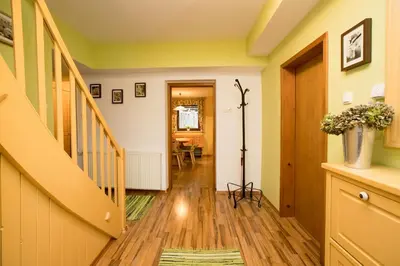 a hallway with yellow walls and wooden floors and a staircase at Apartma Pr Gatej in Bohinj