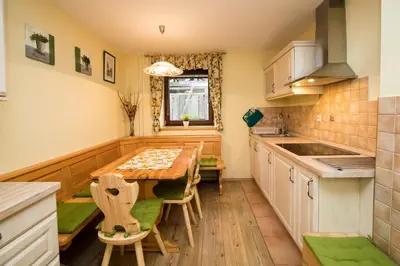 a kitchen with a wooden table and chairs at Apartma Pr Gatej in Bohinj