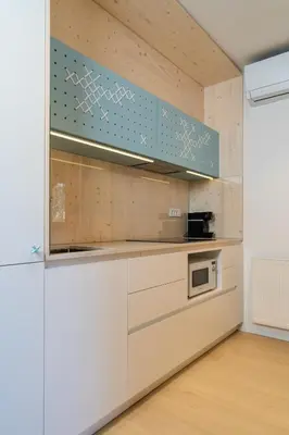 a kitchen with white cabinets and a blue at TD Bohinj Apartments in Bohinj