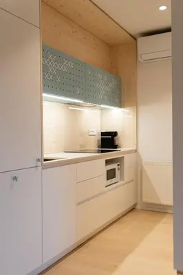 a kitchen with white cabinets and a microwave at TD Bohinj Apartments in Bohinj