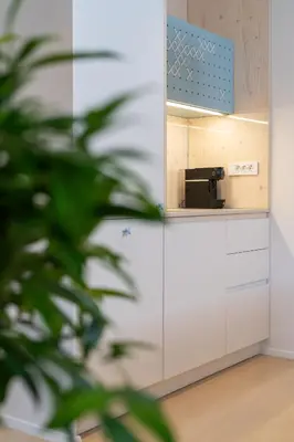 a kitchen with white cabinets and a mirror at TD Bohinj Apartments in Bohinj