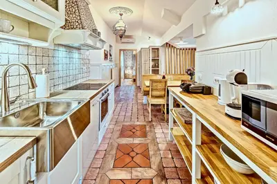 a large kitchen with white cabinets and a sink at Apartments Koledniki in Bled