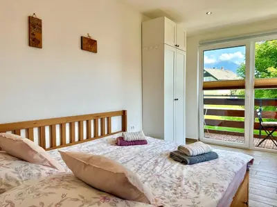a bedroom with two beds and a large window at Two Angels in Bled