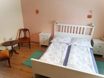 a bedroom with a white bed and a table and chairs at Two Angels in Bled