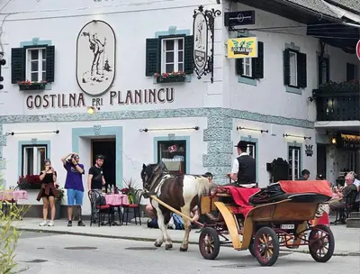 a horse drawn carriage in front of a building at Two Angels in Bled