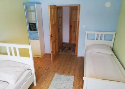 a bedroom with two beds and a hallway at Two Angels in Bled