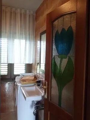 a bathroom with a toilet and a sink and a window at Krasen Kras Apartment in Komen