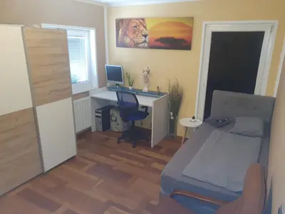 a bedroom with a desk with a computer and a bed at Sanja apartment near to Ljubljana in Preserje pri Radomljah