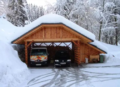two cars parked in a garage covered in snow at Apartment Pod Skalco in Jesenice