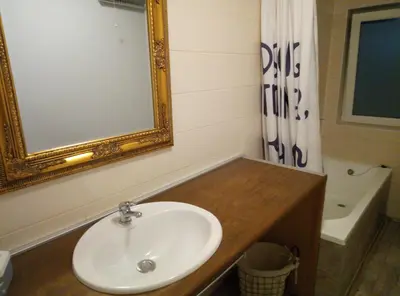 a bathroom with a sink and a mirror and a tub at Hillside Bio Resort Delux Apartments in Šešče pri Preboldu