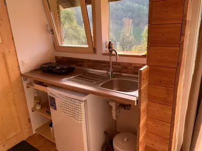 a tiny kitchen with a sink and a window at Hillside Bio Resort Delux Apartments in Šešče pri Preboldu