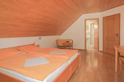 a bedroom with a large bed with a wooden ceiling at Farm Holidays Povsin in Bled