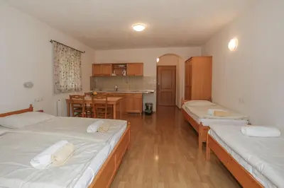 a living room with two beds and a kitchen at Farm Holidays Povsin in Bled