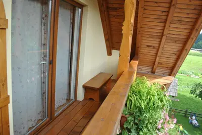 a wooden deck with a bench and a window at Farm Holidays Povsin in Bled