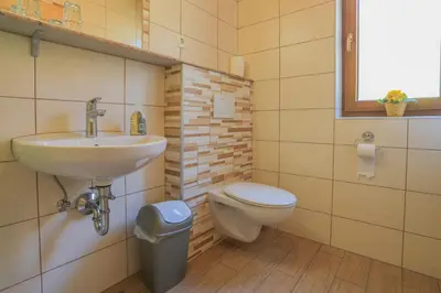 a bathroom with a sink and a toilet and a window at Farm Holidays Povsin in Bled