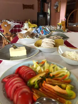 a table with a plate of vegetables and cheese at Guesthouse Draga in Begunje na Gorenjskem