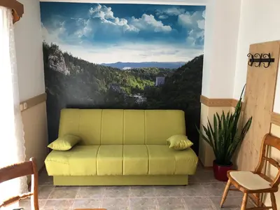 a yellow couch in a room with a view at Guesthouse Draga in Begunje na Gorenjskem