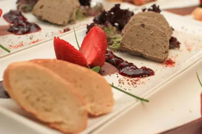 a plate of food with bread and strawberries on it at Guesthouse Draga in Begunje na Gorenjskem