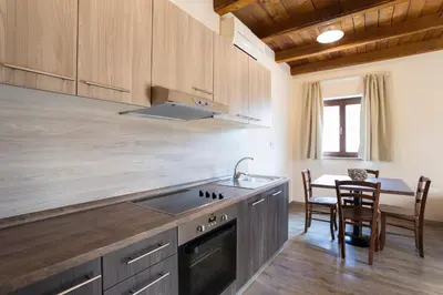 a kitchen with a sink and a table with chairs at Guest House Valentincic in Nova Gorica
